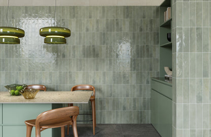 Desayunador en una cocina con muros en tonos verdes.